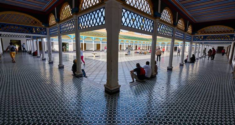 Bâtiment orné avec des personnes assises et se promenant alentour