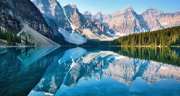 Lac Moraine emblématique avec reflet cristallin des sommets rocheux imposants et de la forêt dense de conifères