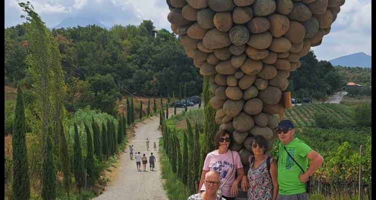 Touristen stehen in der Nähe einer großen Skulptur aus Steinen.