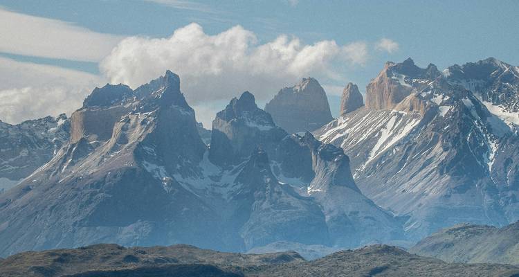 Picos dramáticos de una cordillera con un cielo nublado.