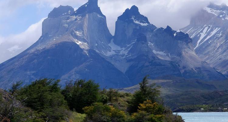 Vista de cerca de montañas con un río y árboles abajo.