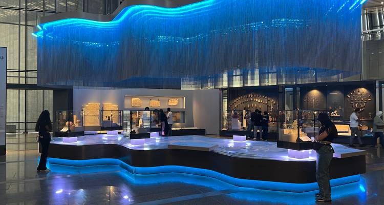 Área de exhibición con visitantes en un entorno de museo moderno.