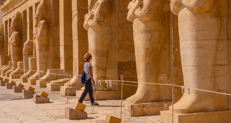 Persona caminando junto a estatuas antiguas en Luxor.