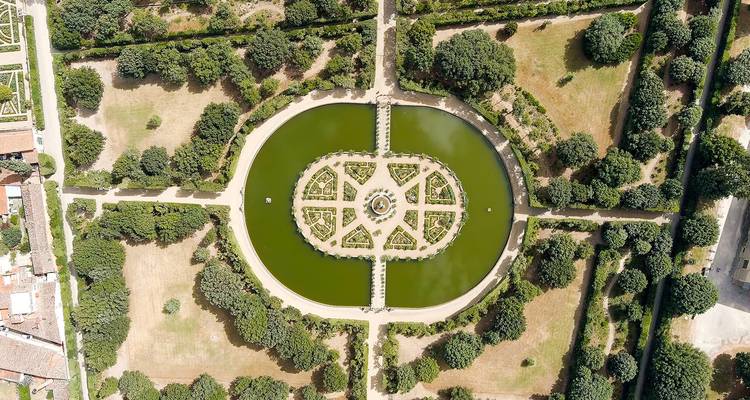 Vue aérienne symétrique d'un jardin italien formel avec des bassins circulaires, des allées et des arbres taillés.