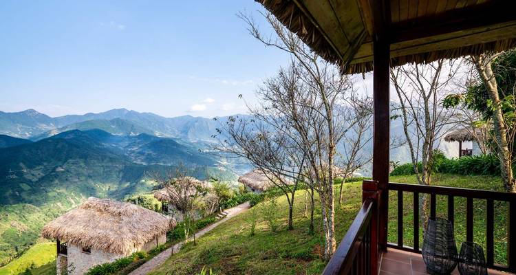 Un balcon en bois surplombe les vallées montagneuses qui s'étendent à perte de vue et les chaumières au toit de paille du Vietnam rural.