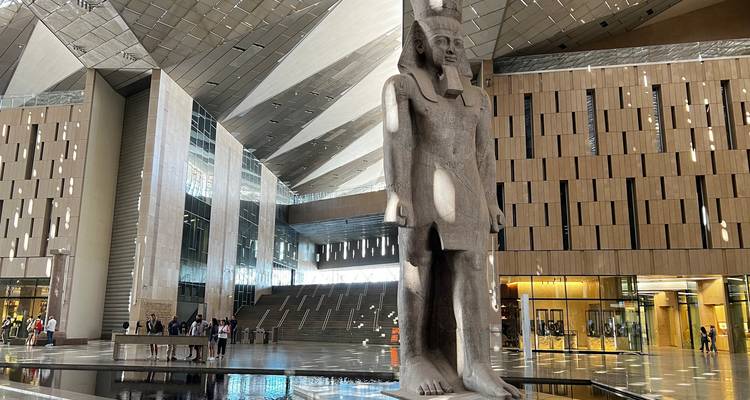 Personas explorando el interior de un museo moderno con artefactos antiguos.