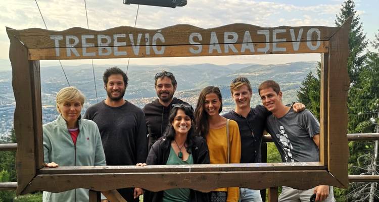 Groupe de personnes posant dans un cadre en bois avec Trebevic Sarajevo écrit dessus.