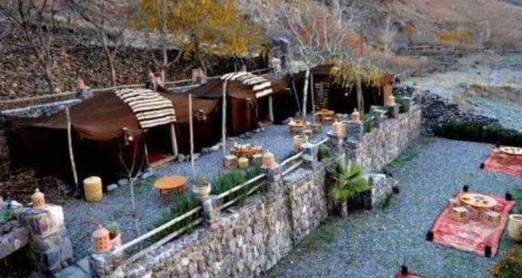 Zelte eingebettet in eine felsige und grüne Landschaft.