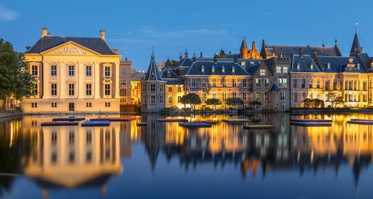 Elegante historische Gebäude des Haager Binnenhofs wunderschön beleuchtet und in stillem Wasser in der Abenddämmerung gespiegelt.