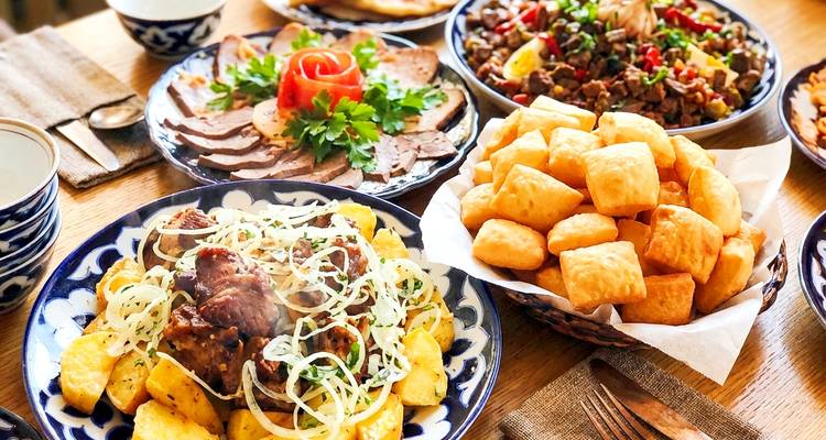 Traditionele Centraal-Aziatische gerechten gerangschikt op een tafel met kleurrijke presentatie.