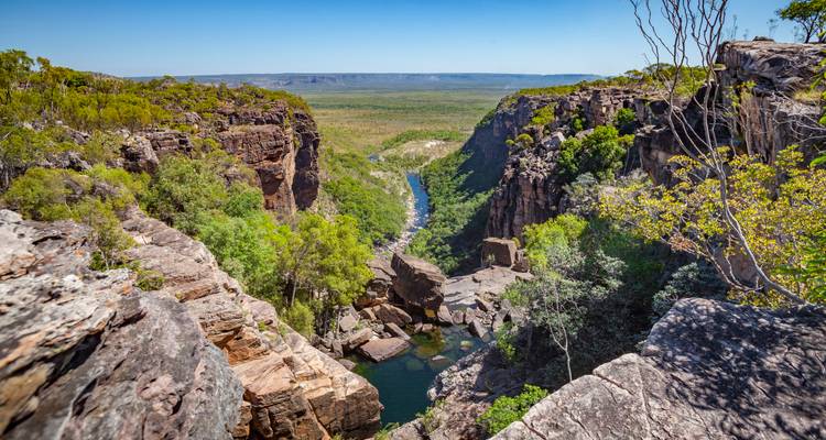 Deep rugged gorge with sheer rock walls and emerald pool in Australia’s outback.