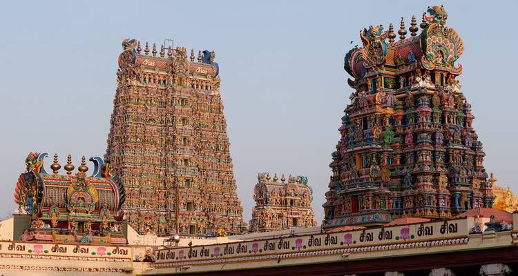Colorful gopurams of a temple against a clear sky.
