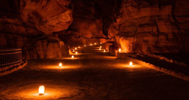 Kaarslicht verlichte Siq-pad slingerend door smalle zandstenen kloof richting Petra.