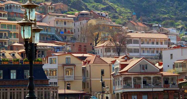Encantadoras casas en la ladera y balcones del Viejo Tiflis con una farola vintage en primer plano.