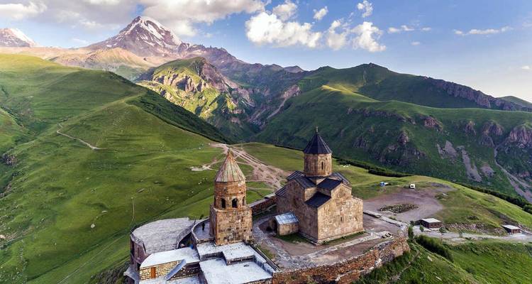 Icónica Iglesia de la Trinidad de Gergeti situada contra las dramáticas montañas del Cáucaso y el Monte Kazbek.