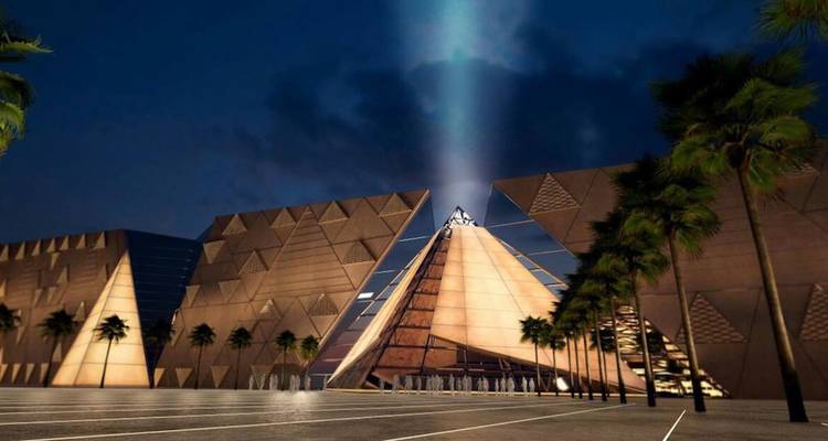 A futuristic building lit up at night with a pyramid shape.