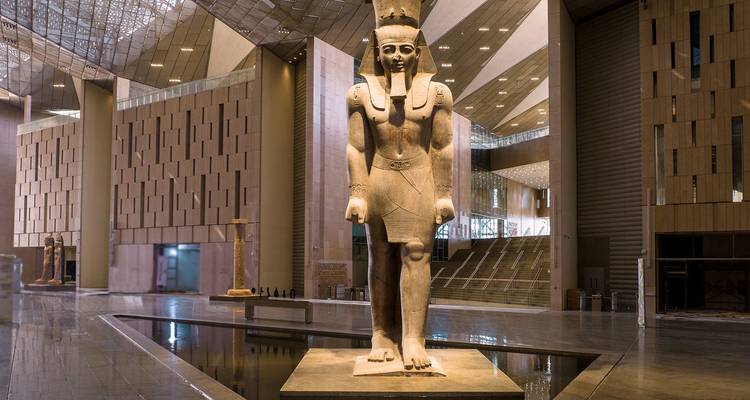 A large statue in an interior space with modern architecture.