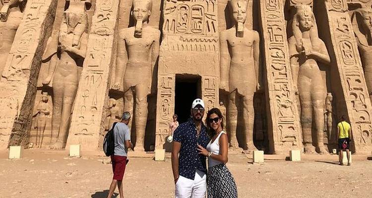 Friends posing in front of an ancient carved façade.