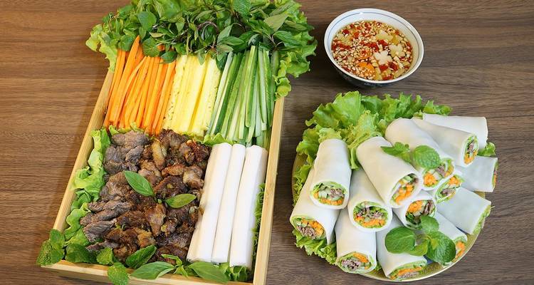 Rollitos vietnamitas frescos de primavera y verduras ordenadamente dispuestos en una bandeja de madera.