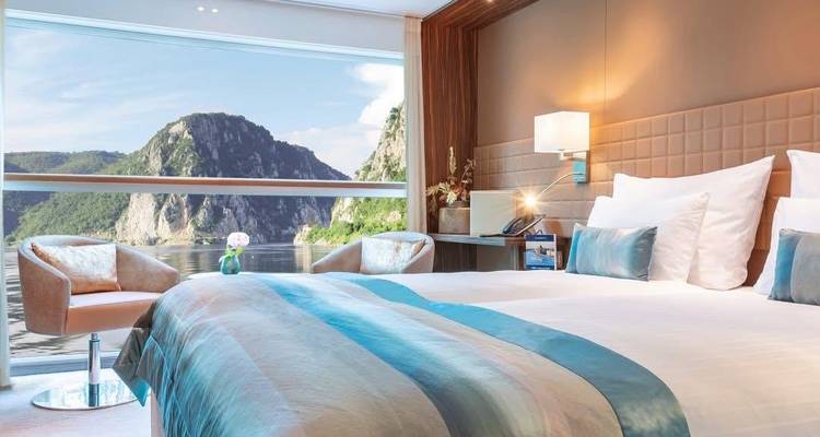 Luxueuze hut met moderne inrichting en een schilderachtig rivieruitzicht vanuit een groot raam.