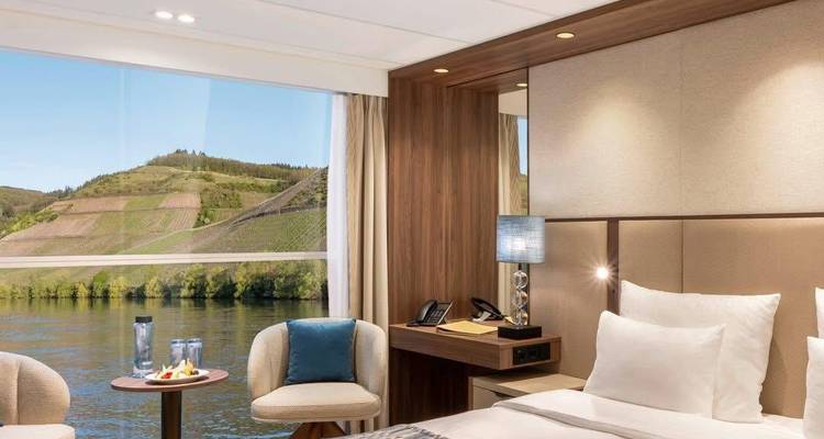 Moderne hotelkamer met open uitzicht op de rivier en het landschap door grote ramen.