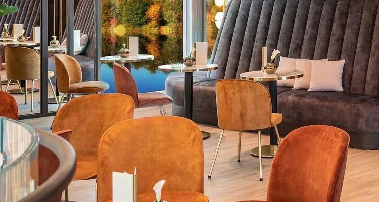 Stijlvolle interieur zithoek op een schip met elegante decoratie en uitzicht op de rivier.