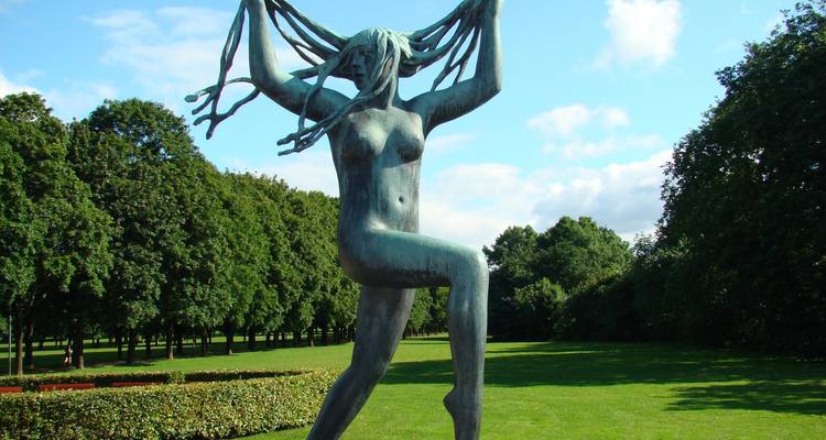 Statue de bronze d'une figure féminine dansante aux cheveux flottants dans la verdure du parc de sculptures de Vigeland.