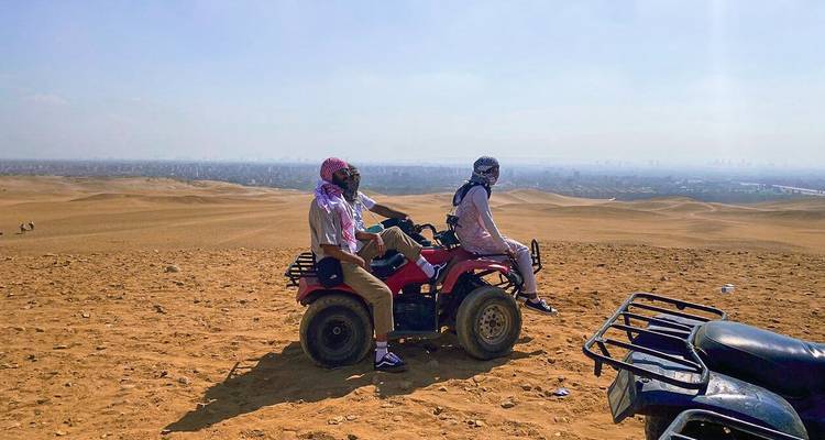 Trois personnes se reposant sur des quads en contemplant le paysage désertique.