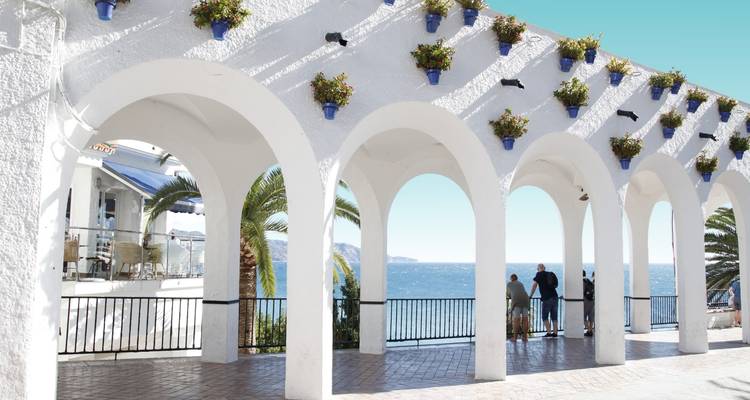 Weiß getünchte Arkade mit Topfblumen, die einen Blick auf das Mittelmeer vom Balcón de Europa in Nerja einrahmen.