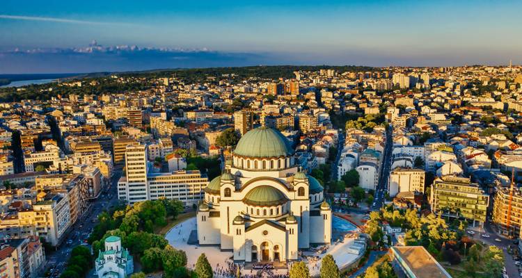 Aerial view of Belgrade dominated by the Church of Saint Sava surrounded by dense urban fabric.