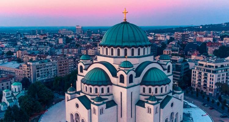 Vue aérienne du temple Saint-Sava à coupole de Belgrade brillant au crépuscule rose au-dessus de la ville