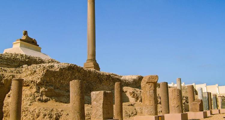 La colonne de Pompée et les ruines environnantes se dressent sous un ciel bleu clair à Alexandrie.