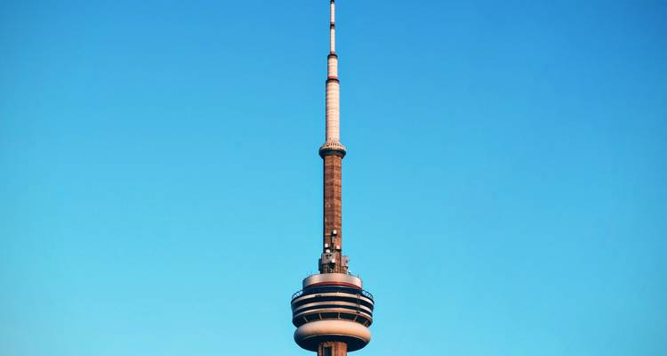 Close-up of Toronto’s CN Tower soaring into a clear blue sky.