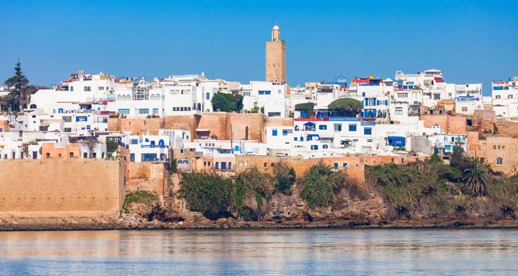 La medina blanca y azul de Rabat y la Kasbah elevándose sobre el río Bouregreg bajo un cielo sin nubes.