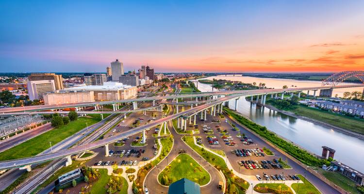 Brede luchtfoto van snelwegknooppunten in Memphis die leiden naar het centrum bij de Mississippi rivier bij zonsondergang.
