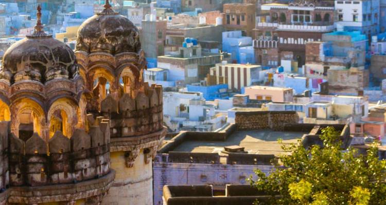Blick über Jodhpurs blaue Stadtdächer, gerahmt von verzierten Steinkuppeln.