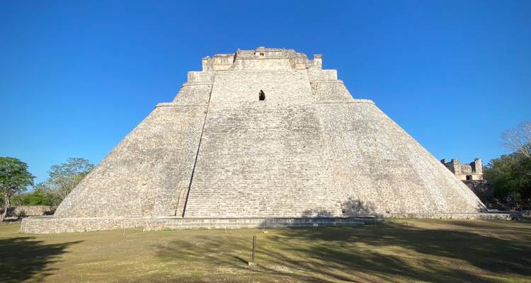 Pyramide imposante du Magicien à Uxmal encadrée par un ciel bleu sans nuages.