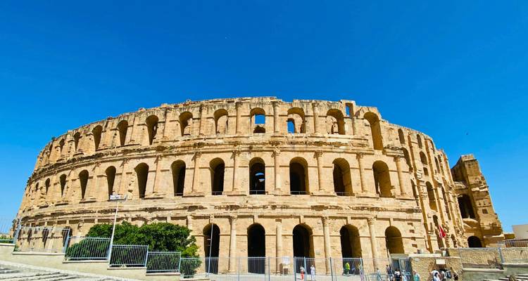 Le vaste amphithéâtre romain d'El Jem se dressant sous un ciel bleu éclatant.
