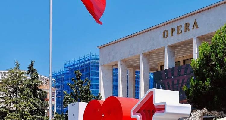 Die albanische Flagge weht neben dem Opernhaus und einer "I ❤️ T"-Skulptur im Zentrum von Tirana.