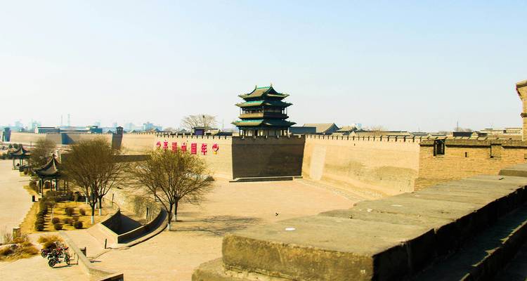 Blick entlang der befestigten grauen Mauern und des Eckturms von Pingyaos historischen Stadtbefestigungen.