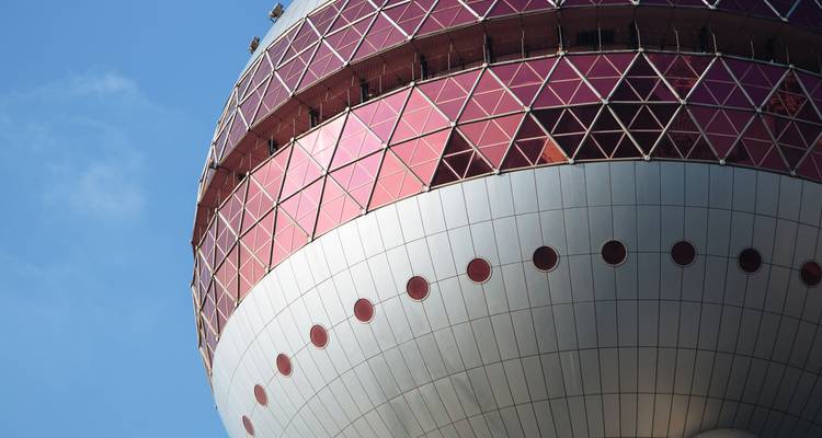 Nahaufnahme eines architektonischen Details des rosa und weißen Oriental Pearl TV Towers vor blauem Himmel.