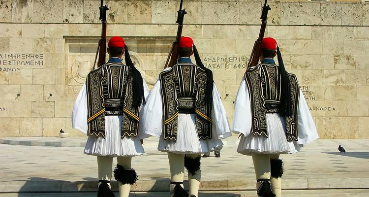 Gardes présidentiels grecs (Evzones) marchant en uniforme traditionnel devant le Tombeau du Soldat inconnu.