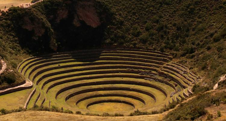 Aerial stone terraces of Moray archaeological site forming concentric circles in dry highland terrain.