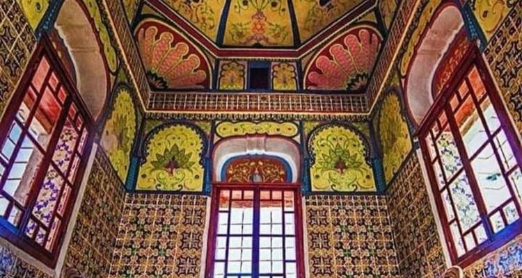 Levendig betegeld interieur met sierlijke patronen en felle kleuren rondom gebogen ramen.