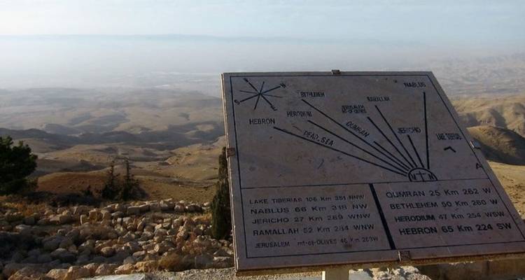 Carte de pierre directionnelle sur le mont Nébo indiquant les distances vers les villes saintes régionales