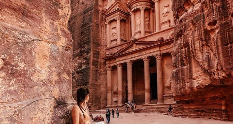 Un visiteur contemple le Trésor de Pétra depuis l'ouverture étroite du canyon rocheux