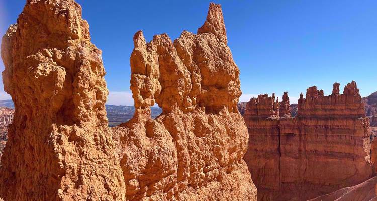 Nahaufnahme von hohen, schmalen Hoodoo-Formationen, die sich gegen den klaren blauen Himmel im Bryce Canyon erheben.