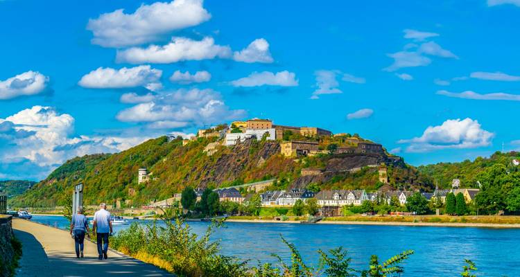 Festung Ehrenbreitstein thront auf einem grünen Hügel über dem Rhein an einem klaren Tag.