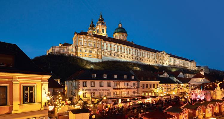 L'abbaye illuminée de Melk domine un marché de Noël animé rempli d'étals scintillants