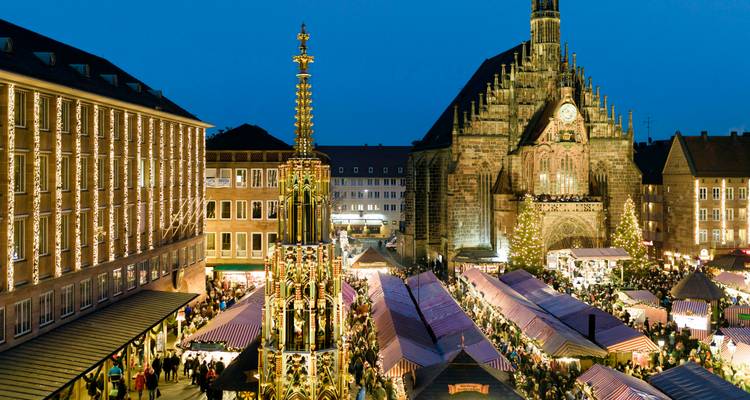 Célèbre Christkindlesmarkt de Nuremberg avec des étals rayés devant la Frauenkirche au crépuscule